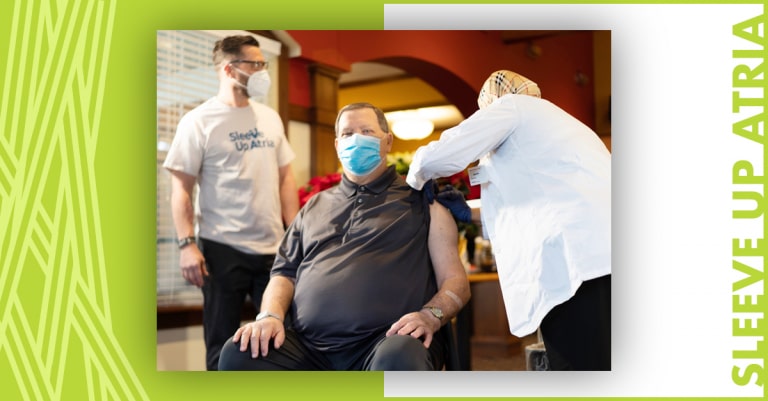 Atria Senior Living employee sleeving up and receiving the COVID-19 vaccine.