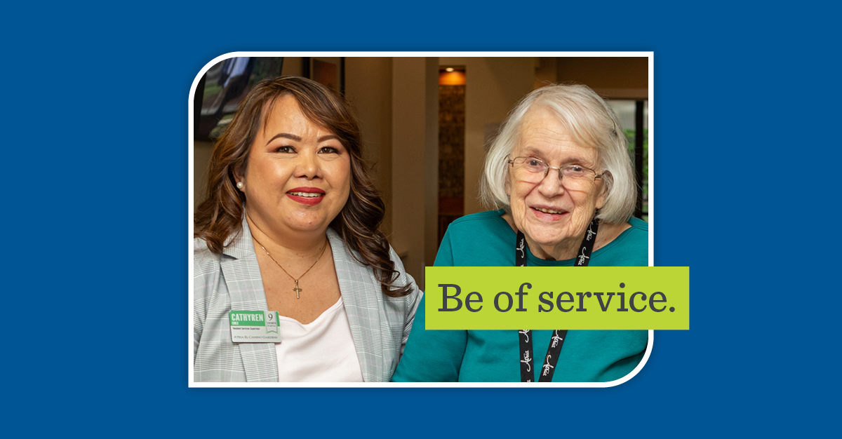 young woman wearing a name badge smiling next to a senior woman. Overlay text reads "be of service"