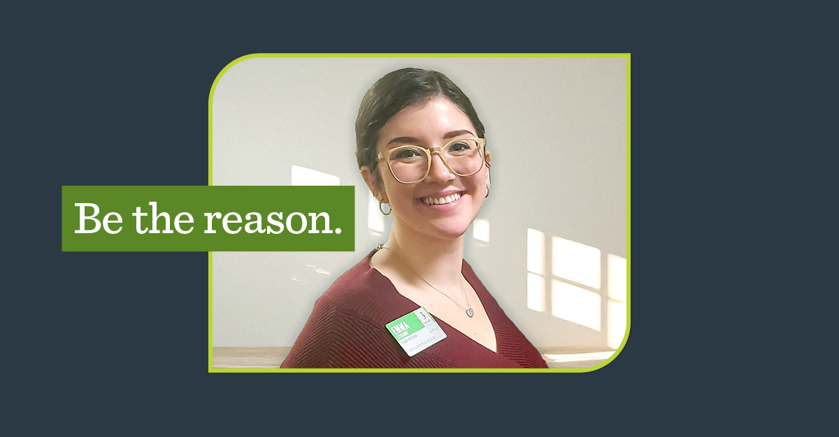 Smiling woman on a navy background and a green overlay that says, "Be the reason"