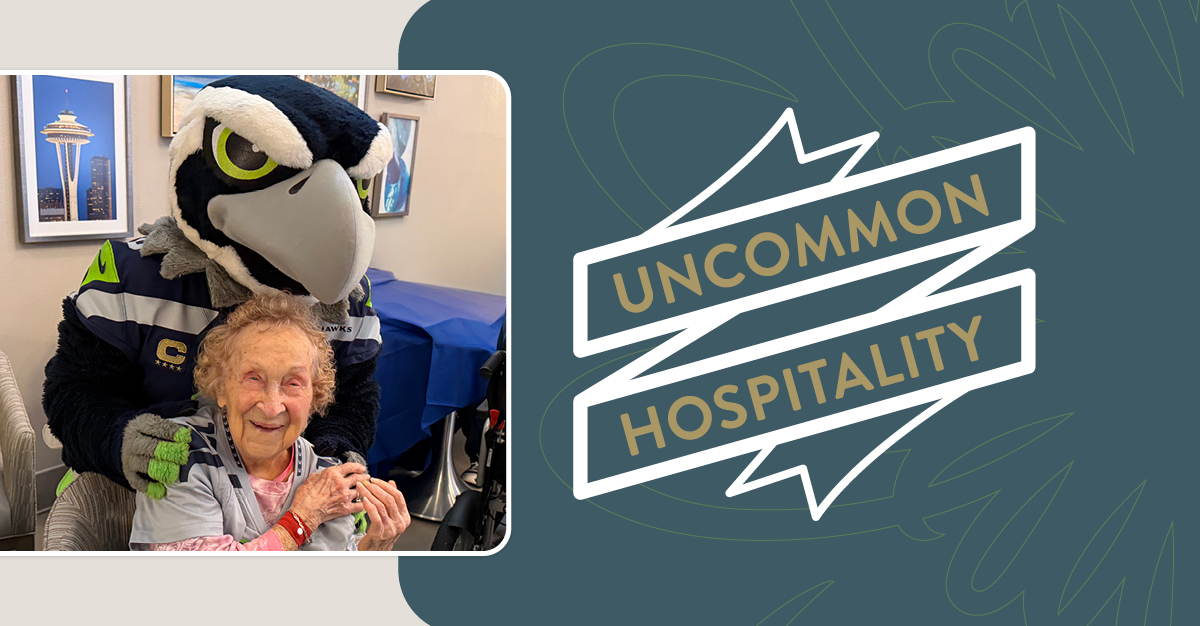 Man in Seattle Seahawks mascot costume poses with an older woman